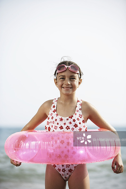 戴着游泳圈和泳镜的女孩（6-8岁），肖像照图片素材