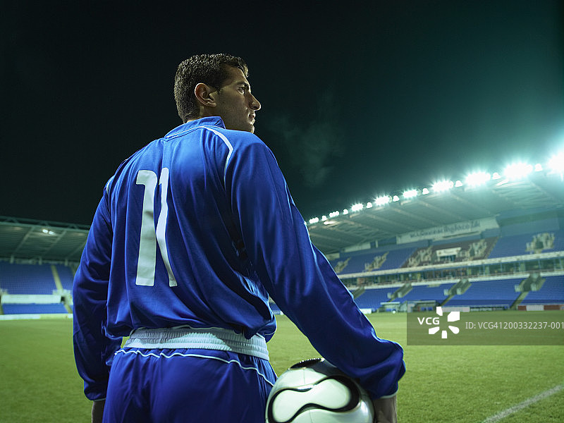 夜晚球场上的年轻足球运动员图片素材