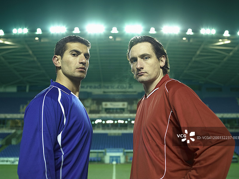 球场上的两名男足球运动员，肖像，夜晚图片素材
