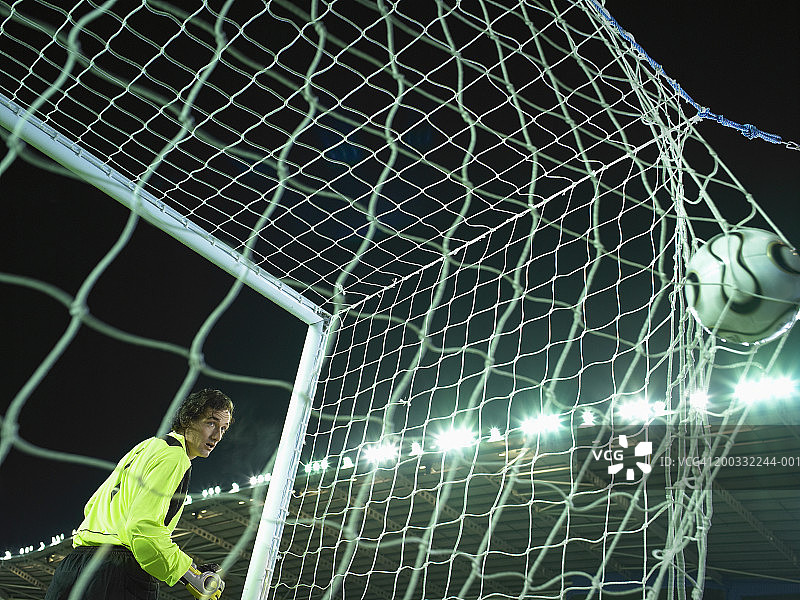 男守门员看着球在球网后方鼓起图片素材