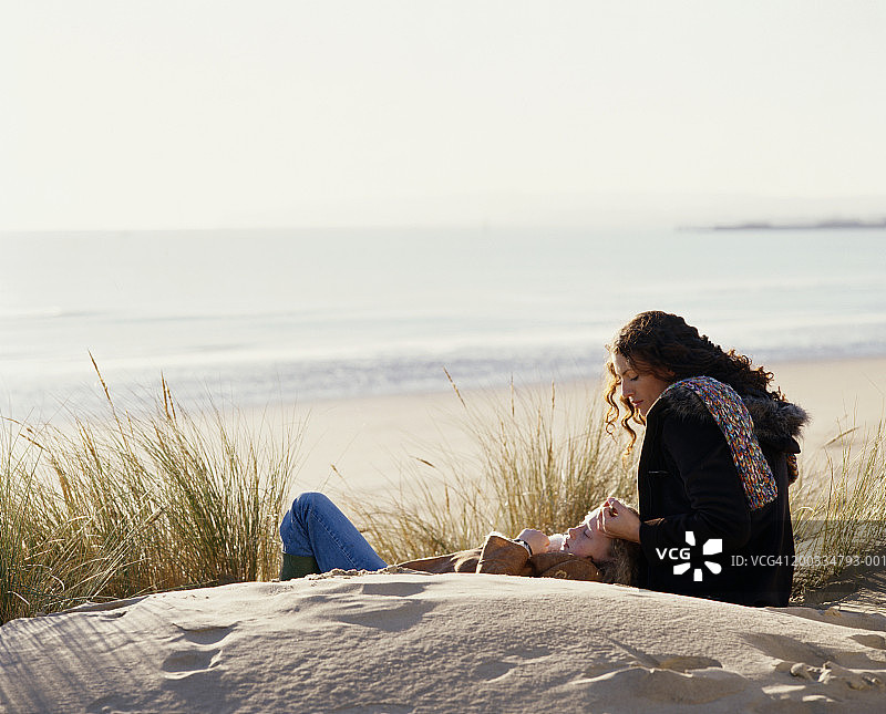 母女在沙滩沙丘上放松身心图片素材