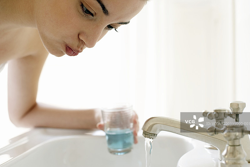 年轻女子在水槽边漱口特写图片素材