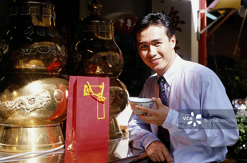 商人街边餐厅端碗微笑肖像图片素材