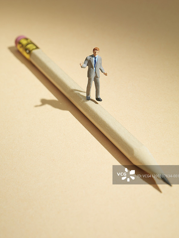 铅笔上的微型男性人偶图片素材