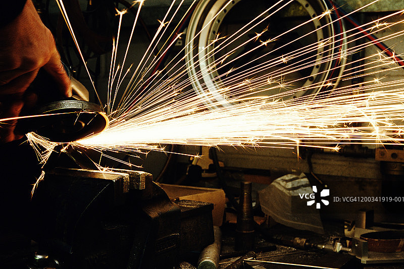 钢铁工人在老虎钳上用角磨机打磨钢材图片素材