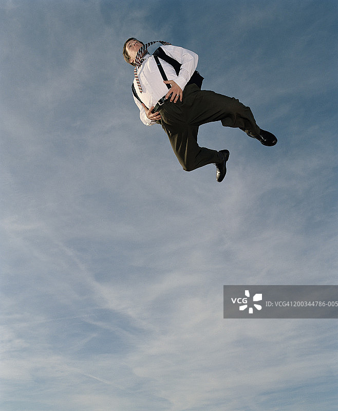商人捂着肚子在半空中，低角度视角图片素材