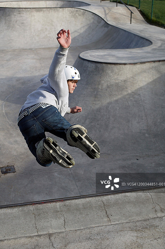 在滑板公园玩直排轮滑的中学生男孩图片素材