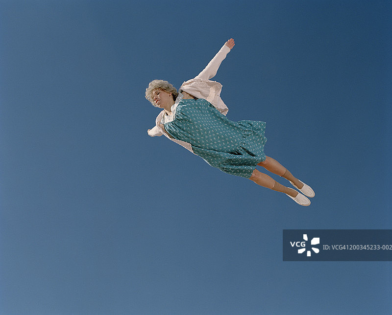 老年妇女在天空中飞行，低角度视角图片素材