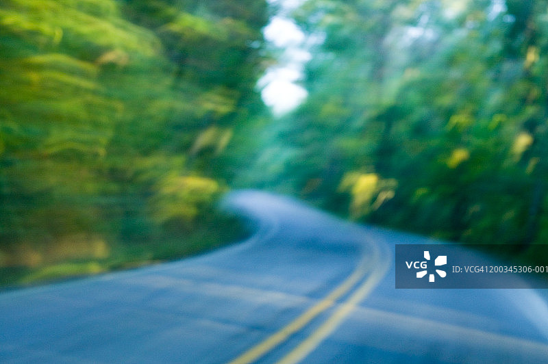 树木环绕的弯曲道路，秋季（长时间曝光）图片素材