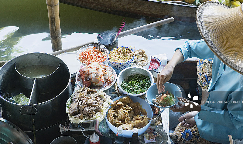 泰国曼谷丹嫩沙多水上市场，妇女烹饪食物图片素材