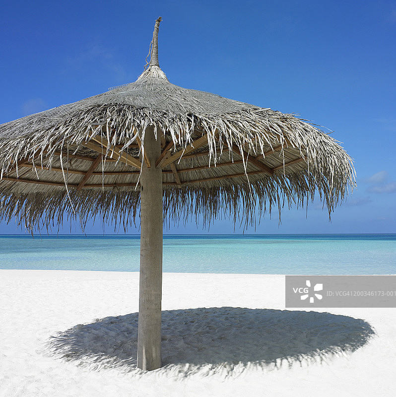 沙滩上的草制遮阳伞图片素材