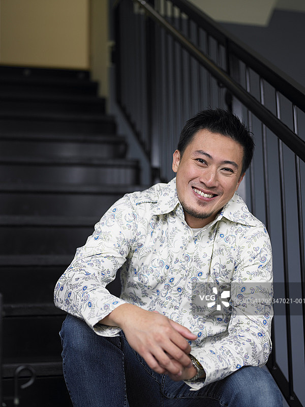 坐在楼梯上微笑的男人肖像图片素材