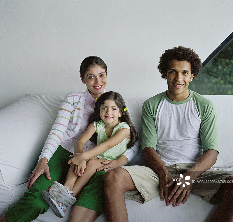 一家人坐在沙发上，肖像图片素材