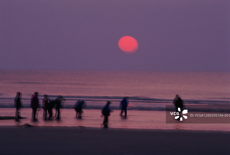 比利时奥斯坦德：黄昏时分海滩上的人们（长曝光）图片素材