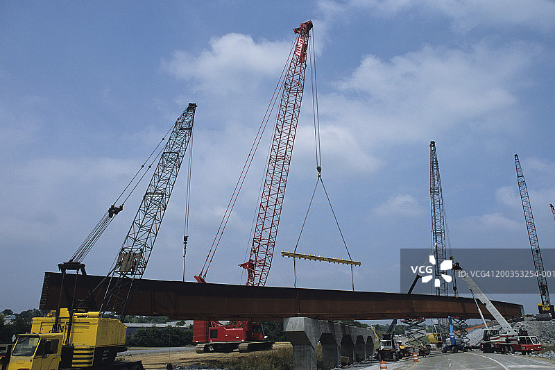 重型建筑，道路建设，起重机吊起巨大的钢板梁图片素材