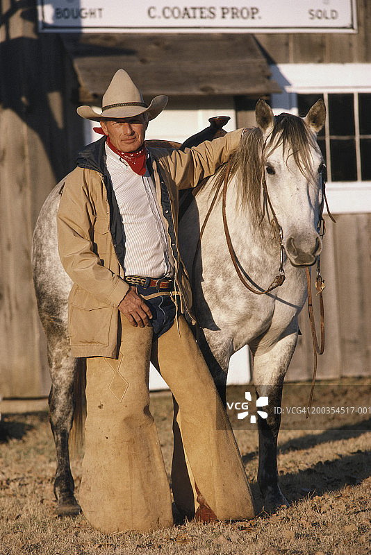 戴着护腿的牛仔与马的肖像图片素材