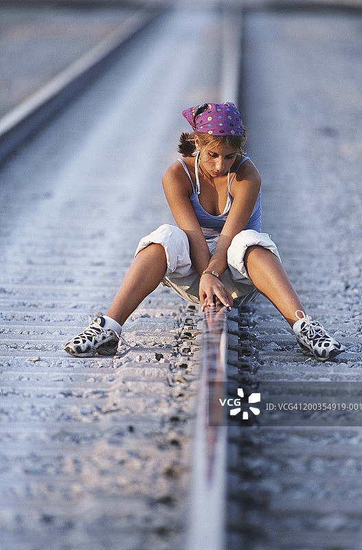 坐在铁路轨道上的少女（15-17岁）图片素材