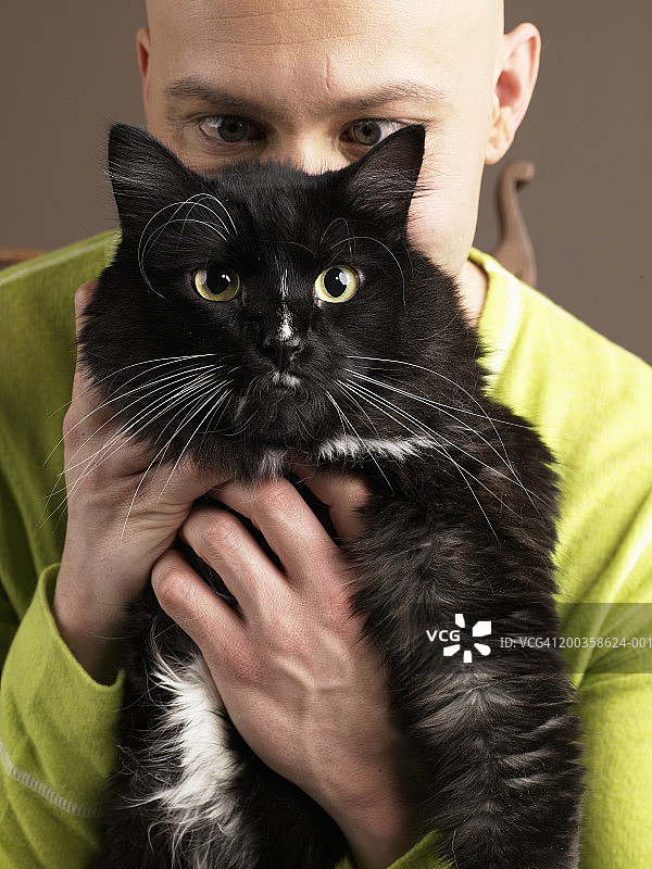 男人抱着猫遮住脸图片素材