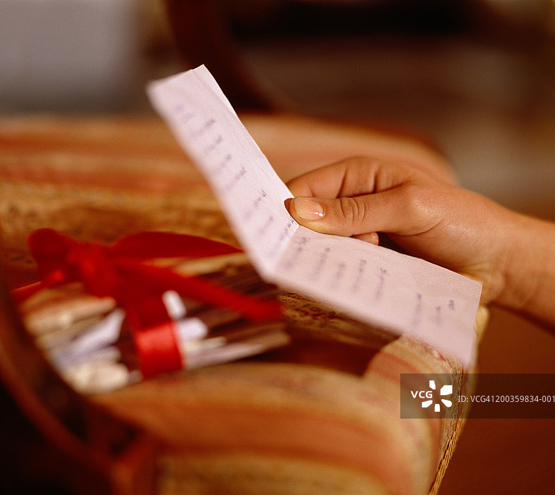 特写：少女（15-17岁）拿着信（聚焦手部）图片素材