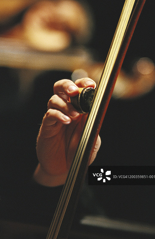 男子给大提琴弓上松香，特写图片素材