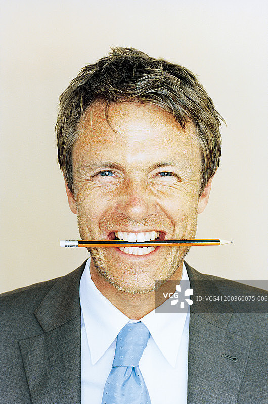 嘴里叼着铅笔的商人特写图片素材