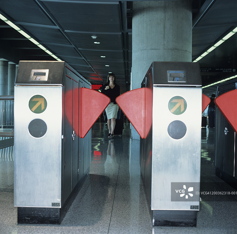 女高管在机场出行，红色地铁旋转栅门图片素材