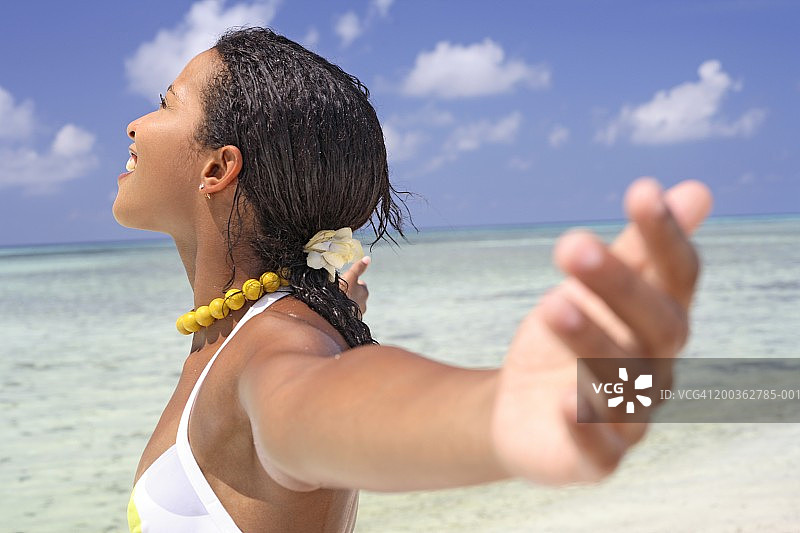 在海滩上伸开双臂的女人图片素材