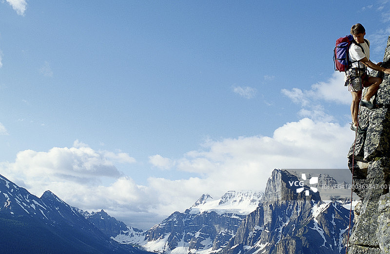 中年男人攀岩，回头看图片素材