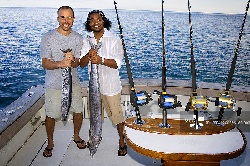 两名男子在船上拿着鱼的肖像图片素材