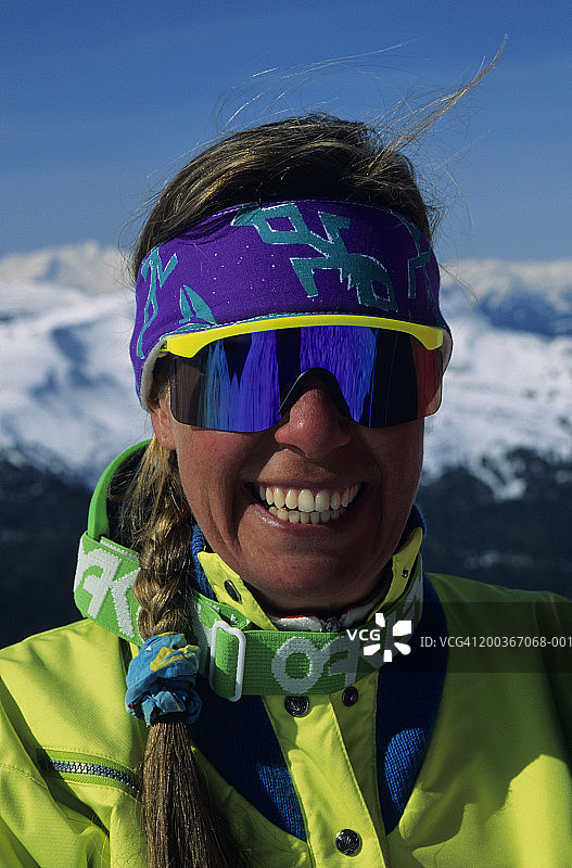 戴反光眼镜的滑雪微笑女性，加拿大不列颠哥伦比亚省，肖像照图片素材