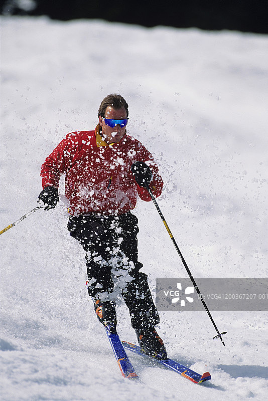 男子在华盛顿州史蒂文斯山口滑雪，雪花飞溅图片素材