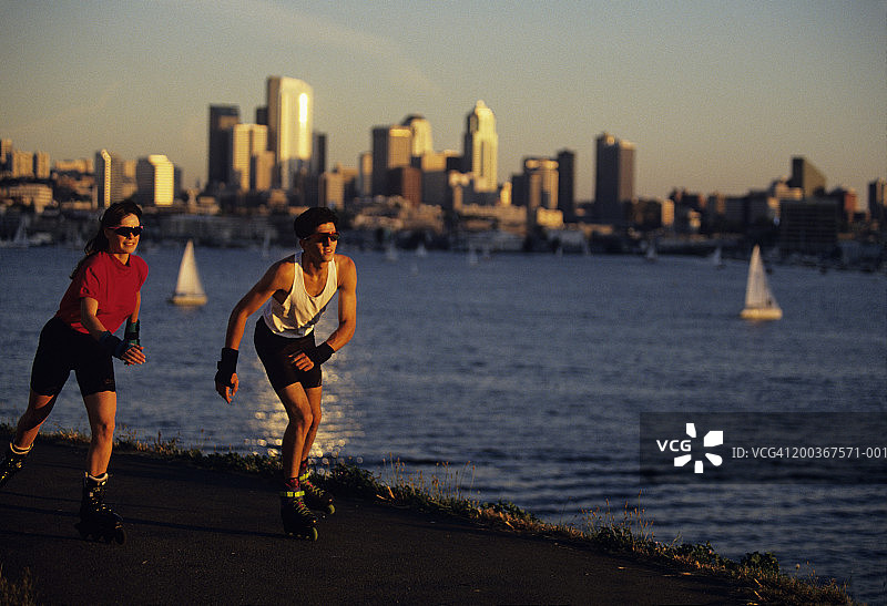 在华盛顿州西雅图煤气厂公园，城市和湖泊背景下玩滑轮图片素材