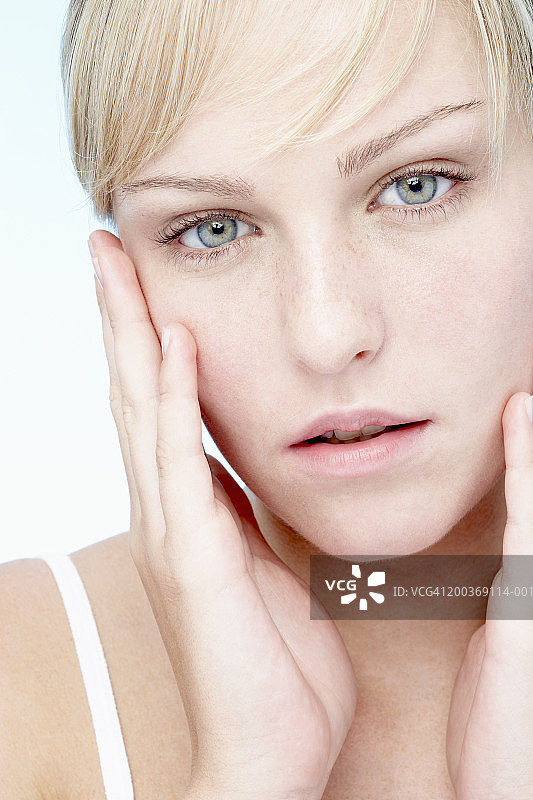 双手抱头的年轻女子肖像特写图片素材