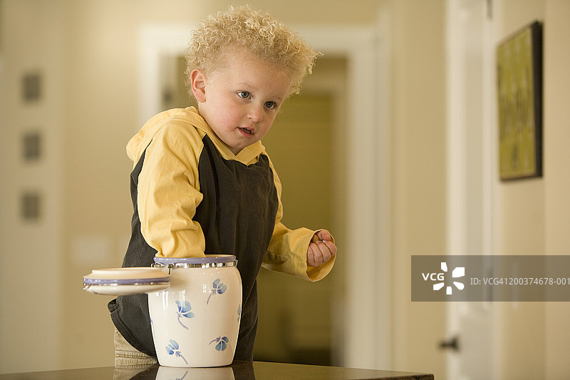 伸手去饼干罐的男孩（2-4岁）图片素材