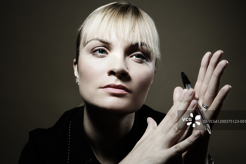 女性手持钢笔，特写图片素材