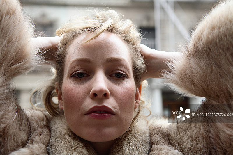 身穿毛皮大衣，向后拢头发的女人肖像图片素材