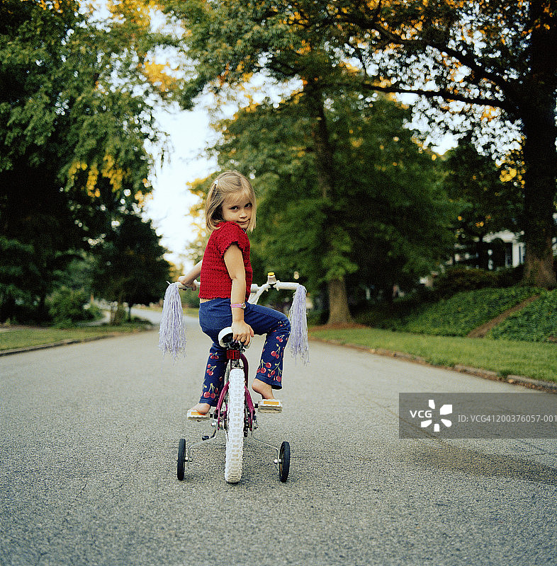 骑着三轮车回头看的女孩（3-5岁）肖像图片素材