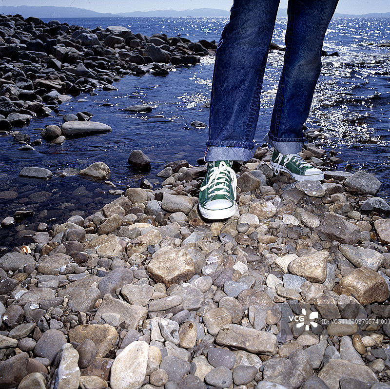 站在水边岩石上的女人（下半身）图片素材
