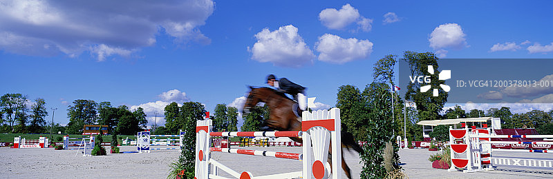 马和骑手参加场地障碍赛（模糊运动）图片素材