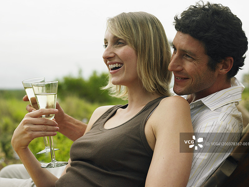情侣在户外喝白葡萄酒，微笑图片素材