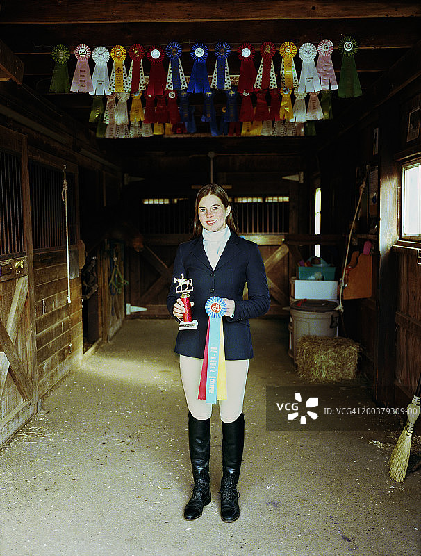 在谷仓里手持奖杯和缎带的少女肖像图片素材