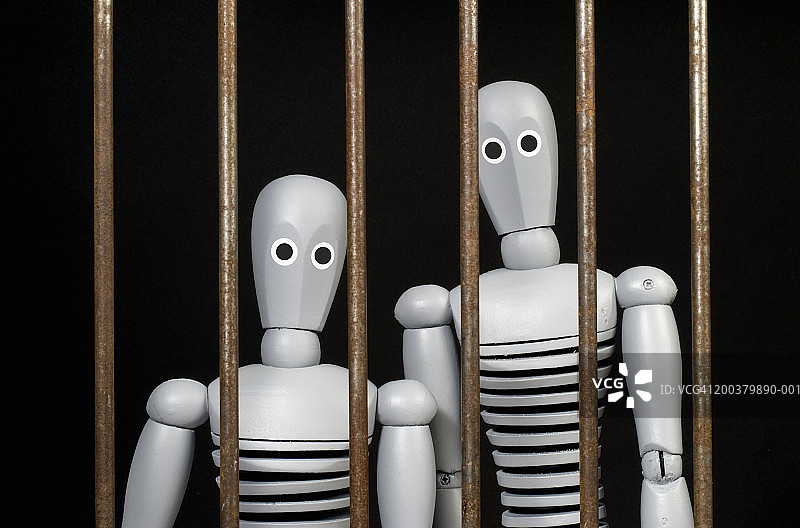 铁栅栏后面的两个人偶图片素材