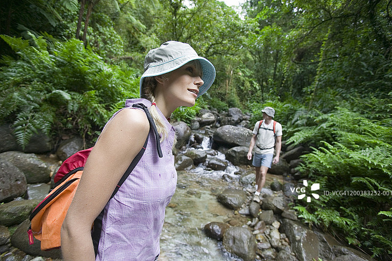 情侣在森林小溪旁，女人在前景中图片素材