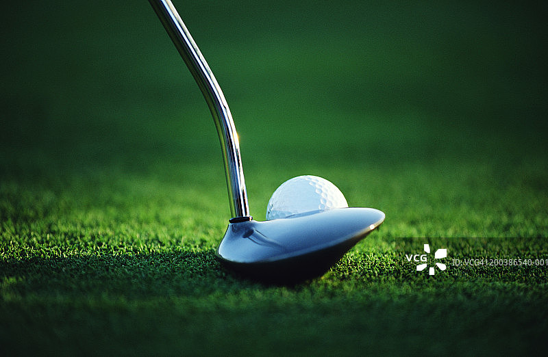 绿色草地上的高尔夫推杆和球图片素材