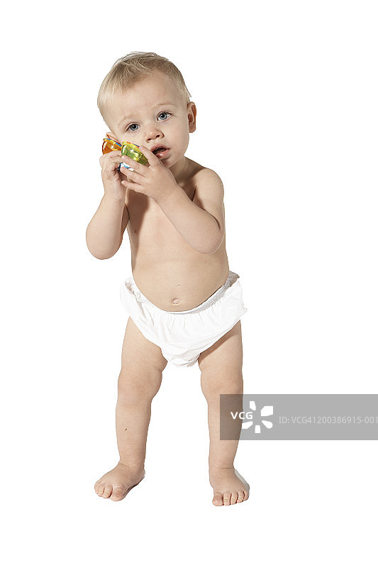 男婴（15-18个月）拿着玩具电话听筒放在耳边图片素材