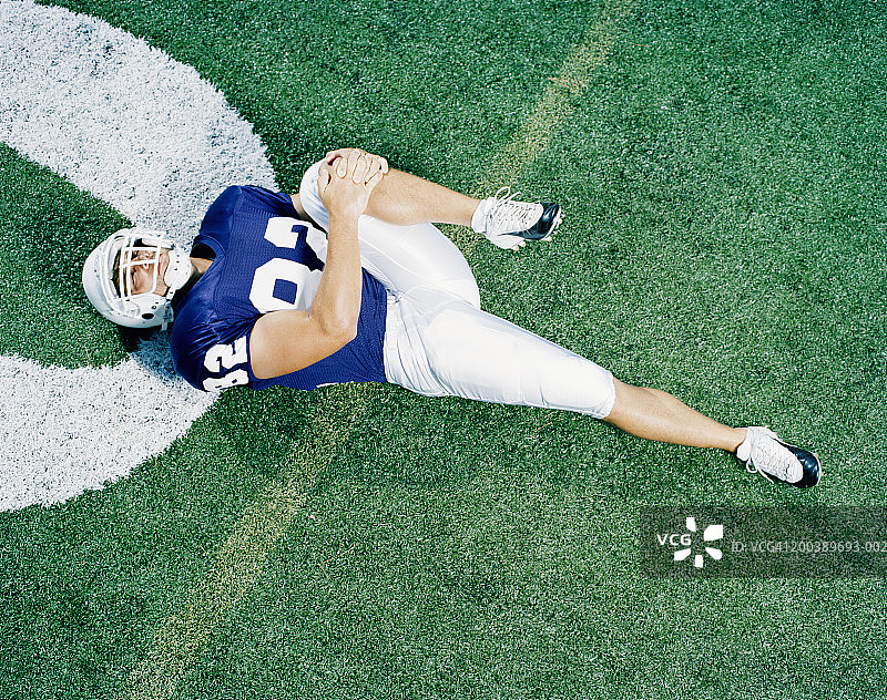 橄榄球运动员在10码线上伸展运动，高角度视角图片素材