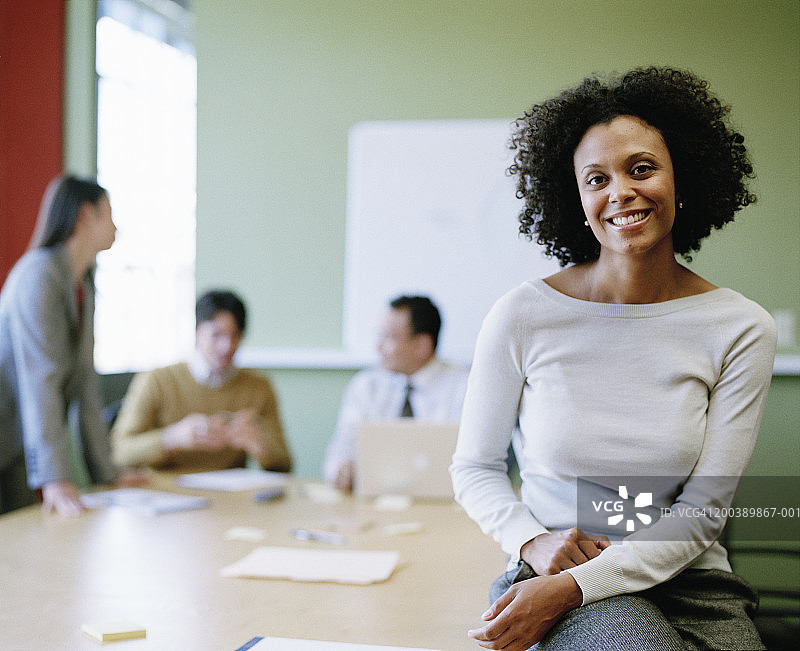 董事会会议中的高管（聚焦前景中的年轻女性）图片素材