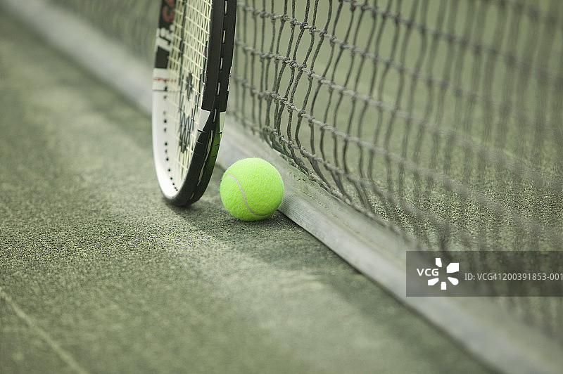 球场上球网附近的网球和球拍图片素材
