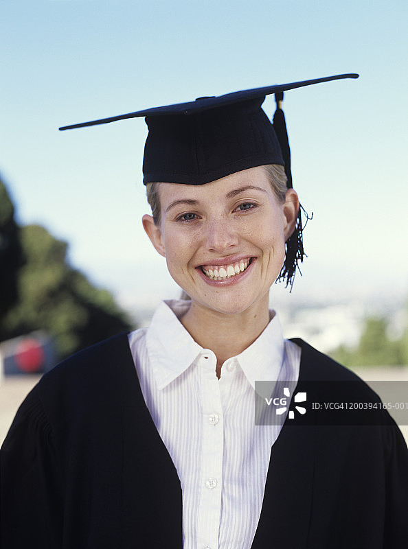 身穿毕业礼服微笑的年轻女人肖像图片素材