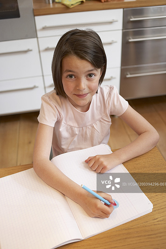 在厨房里给书上色的女孩（6-8岁），微笑，肖像图片素材